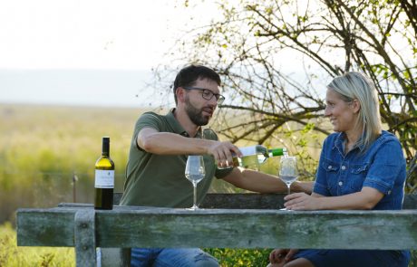 Michael und Elisabeth Nekowitsch sitzen an einem Picknickplatz und trinken Wein